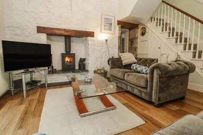 a living room with a couch and a fireplace at Glenside House in Carbis Bay