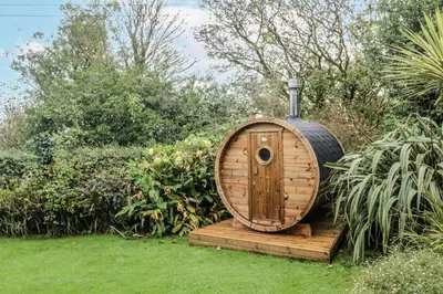 a wooden hobbit house sitting in a garden at Glenside House in Carbis Bay