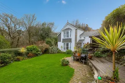 a house with a green lawn in front of it at Glenside House in Carbis Bay