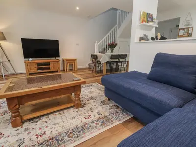 a living room with a couch and a tv at Chellowdene Cottage in Falmouth