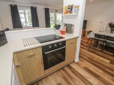a kitchen with a sink and a stove top oven at Chellowdene Cottage in Falmouth