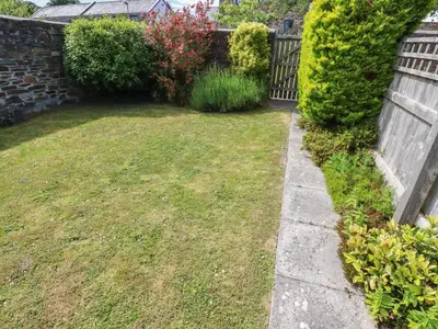 a backyard with a fence and a yard withgrass at Spinnaker in St Austell