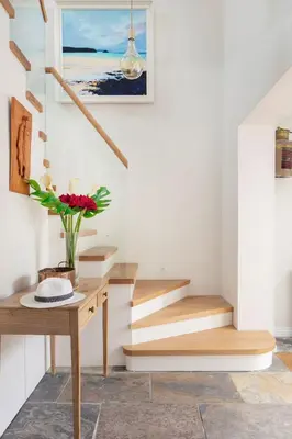 a staircase in a house with a table and flowers at High Meadows in Saint Mawes