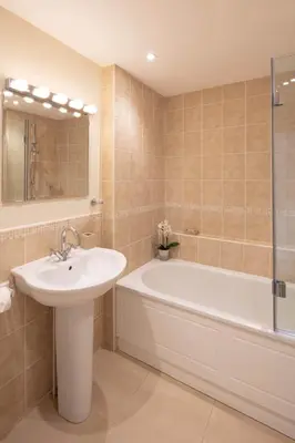 a bathroom with a tub and a sink and a bath tub at High Meadows in Saint Mawes