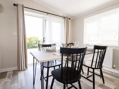 a dining room with a table and chairs and a window at 63 The Maples in St Austell