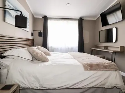 a bedroom with a white bed with a window at 63 The Maples in St Austell