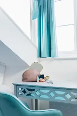 a table with a purse and a blue chair at NEW! Stunning 2 Bed Beach Front Penthouse Apartment - Topaz, Compass Point in Carbis Bay