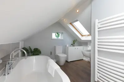a white bathroom with a sink and a bath tub at Spernenwyn in St Ives