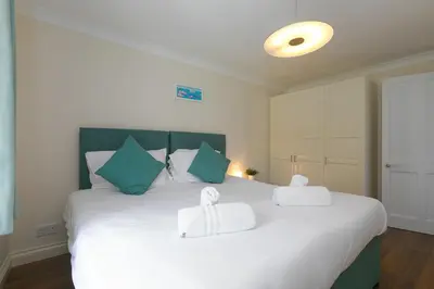 a bedroom with a large white bed with two towels on it at Spernenwyn in St Ives