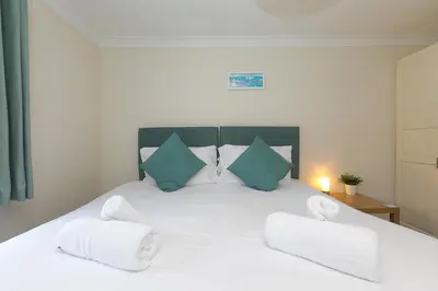 a bedroom with a white bed with two pillows at Spernenwyn in St Ives