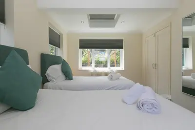 two white beds in a room with a window at Spernenwyn in St Ives