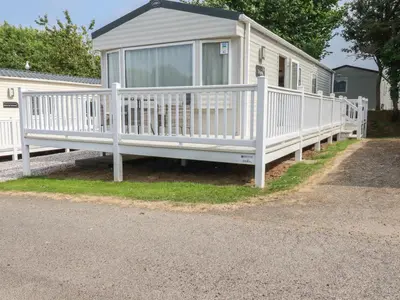 a white porch on a house with a fence at Chez Nous in Newquay