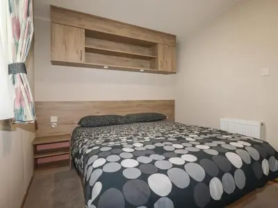 a bedroom with a bed with a black and white comforter at Chez Nous in Newquay