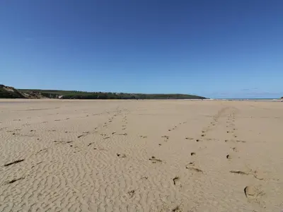 a sandy beach with footprints in the sand at Chez Nous in Newquay