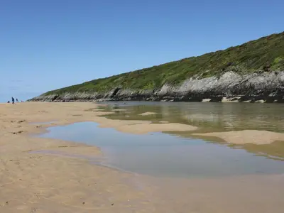a sandy beach with a body of water at Chez Nous in Newquay