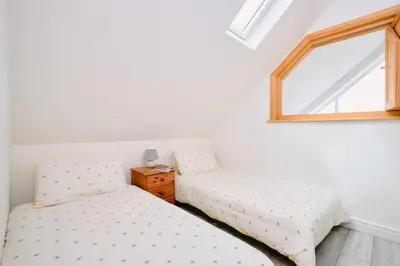two twin beds in a room with a window at Sunset View, near Gwithian & St.Ives Bay in Gwithian
