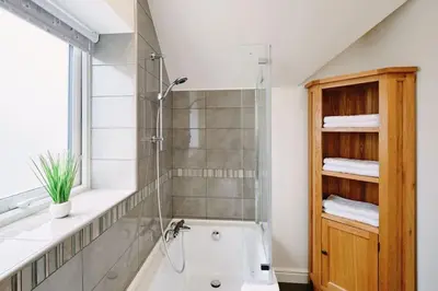 a bathroom with a shower and a white bath tub at Sunset View, near Gwithian & St.Ives Bay in Gwithian