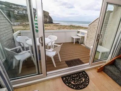 a balcony with a table and chairs and the beach at 16 Seaspray in Truro