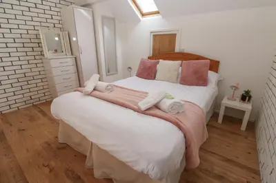 a bedroom with a large bed with towels on it at 16 Seaspray in Truro