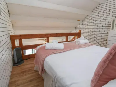 a bedroom with two beds and a tv in a room at 16 Seaspray in Truro