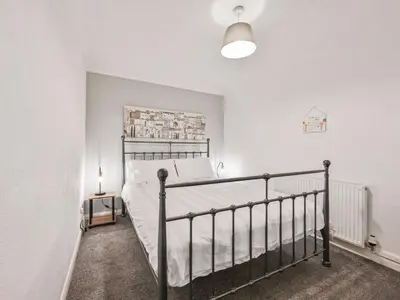 a bedroom with a bed and a white wall at Apartment Rock Pools by Interhome in Mevagissey