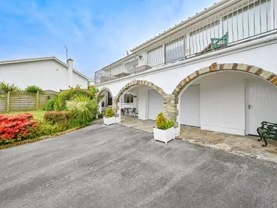 a building with two garage doors and a parking lot at Apartment Rock Pools by Interhome in Mevagissey