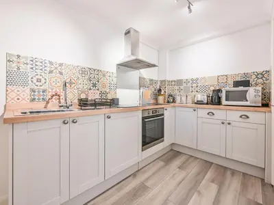 a kitchen with white cabinets and a counter top at Apartment Rock Pools by Interhome in Mevagissey