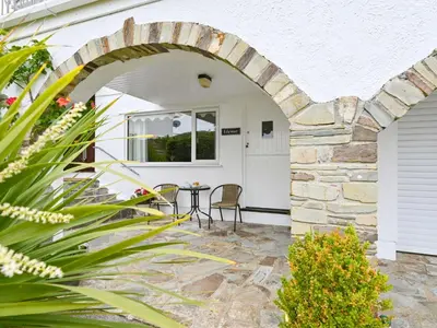 an archway leading to a patio with a table at Apartment Rock Pools by Interhome in Mevagissey