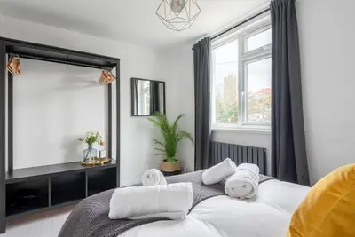 a bedroom with a white bed and a window at Spacious, Modern Home, Central Newquay w/ parking in Newquay