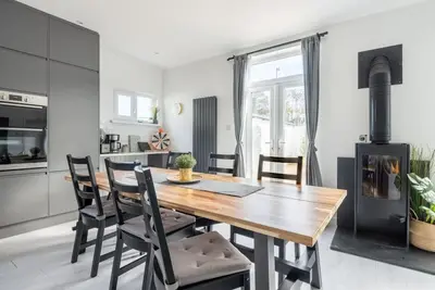 a kitchen and dining room with a wooden table and chairs at Spacious, Modern Home, Central Newquay w/ parking in Newquay