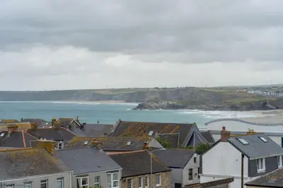 a town with houses and the ocean in the background at Stylish & Modern Home, Central Newquay w/parking in Newquay