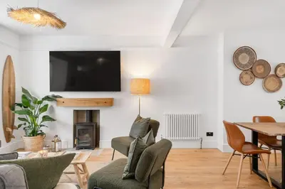 a living room with a fireplace and a tv on the wall at Stylish & Modern Home, Central Newquay w/parking in Newquay