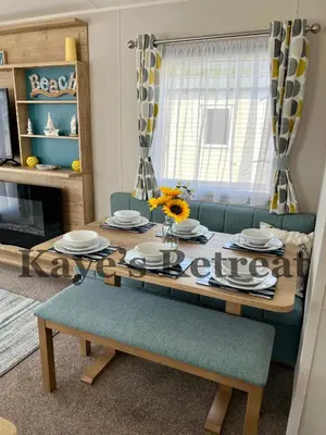 a dining room table and chairs with a table and a dining room at Kayes Retreat Three bed caravan Newquay Bay Resort Quieter area of park in Newquay
