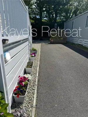 a row of flower pots on the side of a driveway at Kayes Retreat Three bed caravan Newquay Bay Resort Quieter area of park in Newquay