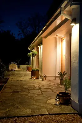 a patio with potted plants and a house at night at Nearwater in Saint Mawes