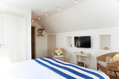 a bedroom with a bed and a tv on a wall at Nearwater in Saint Mawes