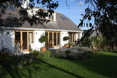 a white house with a garden in front of it at Nearwater in Saint Mawes