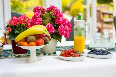a table with a bowl of fruit and a vase of flowers at Polraen Country House Hotel in Looe
