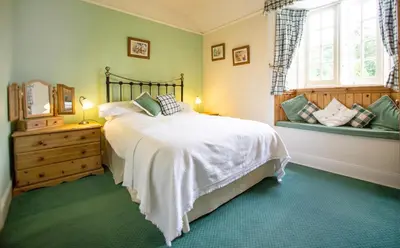 a bedroom with a large white bed and a window at Polraen Country House Hotel in Looe