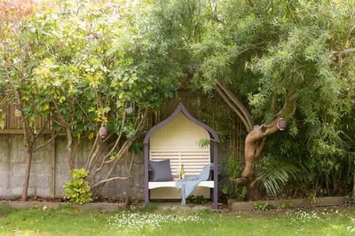 a chair in a gazebo under a tree at Mermaid Cottage, Carbis Bay in Carbis Bay
