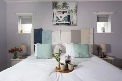 a white bed with a tray with candles on it at Mermaid Cottage, Carbis Bay in Carbis Bay
