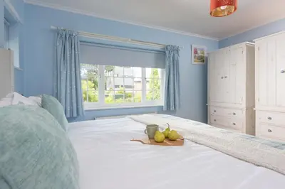 a bedroom with a bed with a window and a plate of fruit on it at Mermaid Cottage, Carbis Bay in Carbis Bay