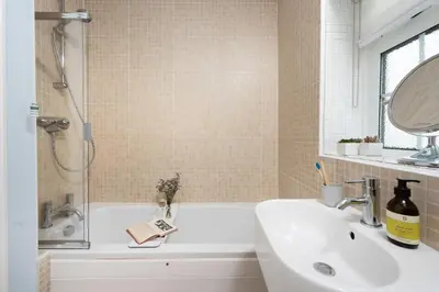 a bathroom with a tub and a sink and a mirror at Mermaid Cottage, Carbis Bay in Carbis Bay