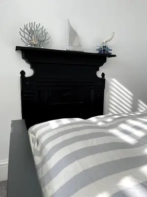 a bedroom with a bed with a black headboard at Contemporary 3-Bedroom Home with Stunning Views in Looe