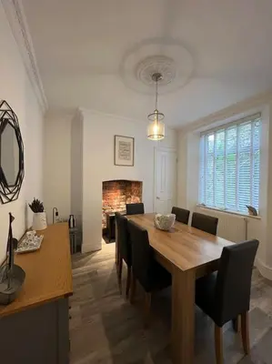 a dining room with a table and chairs and a fireplace at Contemporary 3-Bedroom Home with Stunning Views in Looe