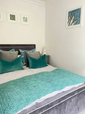a bedroom with a large bed with green pillows at Contemporary 3-Bedroom Home with Stunning Views in Looe