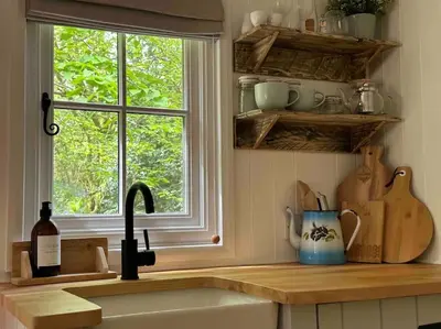 a kitchen counter with a sink and a window at Cornwall Woodland Shepherd's Hut with Hot Tub - Deirdres Hut in Bodmin