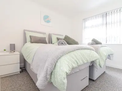 a white bedroom with a bed and a window at Apple Tree Bungalow in Redruth