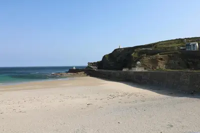 a sandy beach next to the ocean on a cliff at Apple Tree Bungalow in Redruth