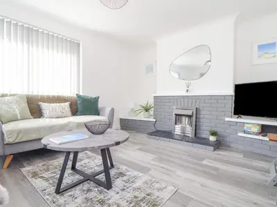 a living room with a couch and a fireplace at Apple Tree Bungalow in Redruth